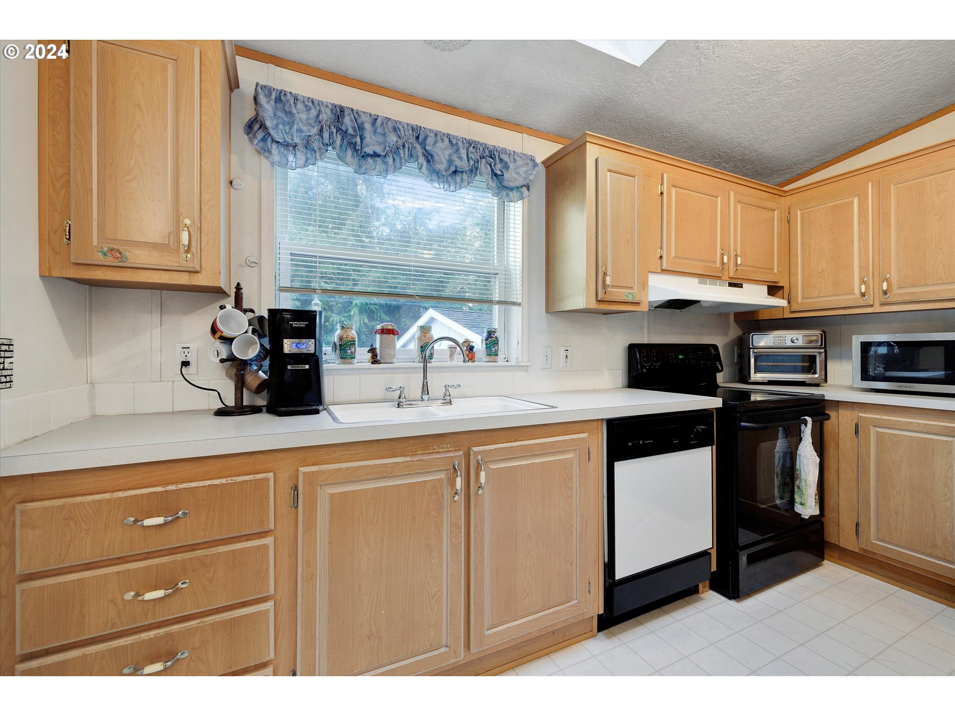 8750 Southeast 155th Avenue, Unit 53 Happy Valley, OR 97086 - Photo 17 of 29 a kitchen with stainless steel appliances granite countertop a sink a stove and cabinets