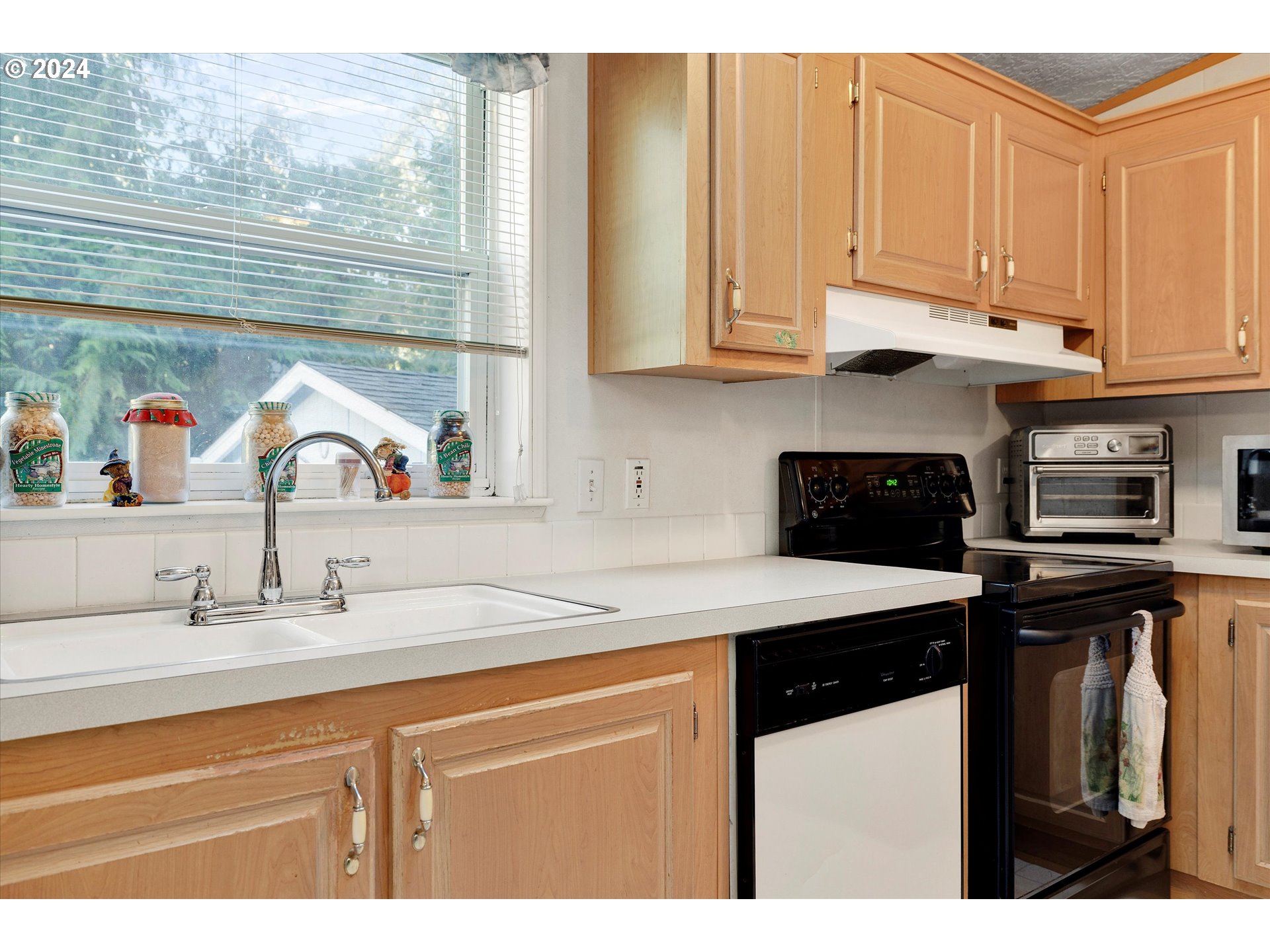 8750 Southeast 155th Avenue, Unit 53 Happy Valley, OR 97086 - Photo 18 of 29 a kitchen with stainless steel appliances granite countertop a sink a stove and a microwave