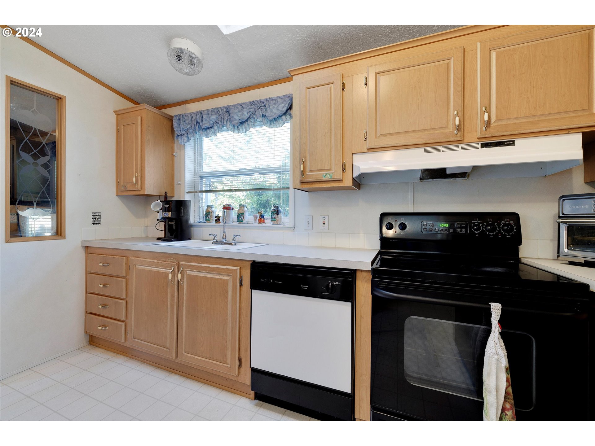 8750 Southeast 155th Avenue, Unit 53 Happy Valley, OR 97086 - Photo 19 of 29 a kitchen with stainless steel appliances granite countertop a stove a sink and a microwave