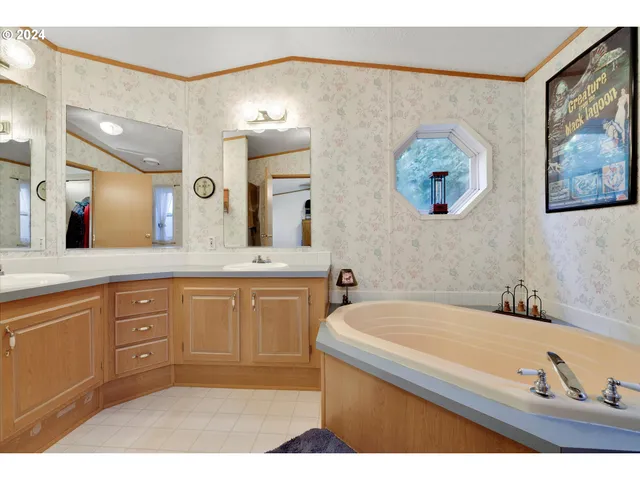 a bathroom with a tub a sink and a mirror