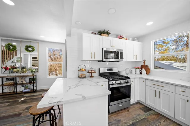 a kitchen with granite countertop a stove sink and microwave