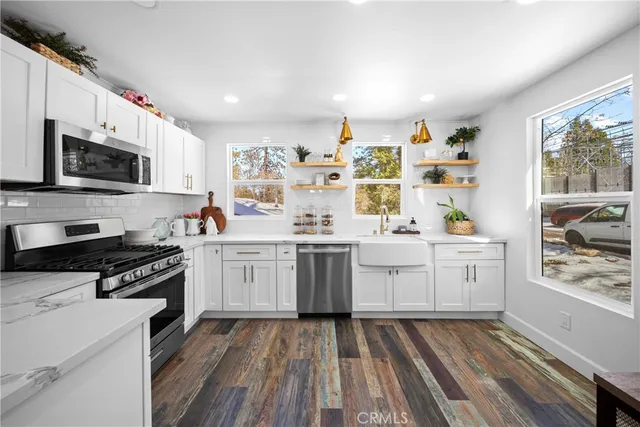 a kitchen with a sink window and stainless steel appliances