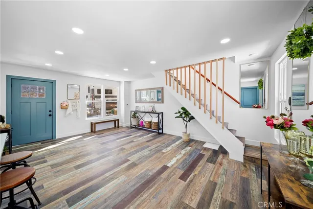 a view of a hallway with wooden floor and staircase