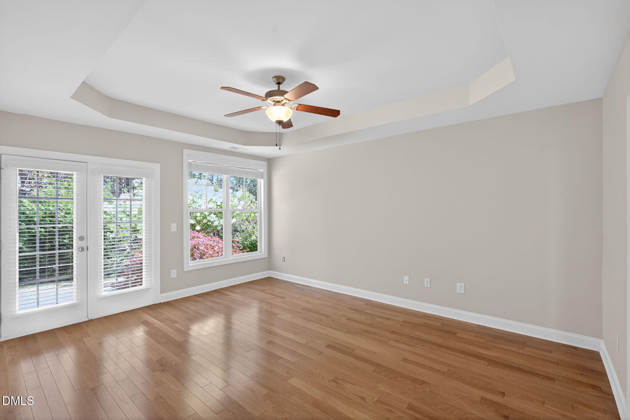 3834 Cumberland Pond Road Raleigh, NC 27606 - Photo 12 of 31 an empty room with wooden floor and windows with curtains