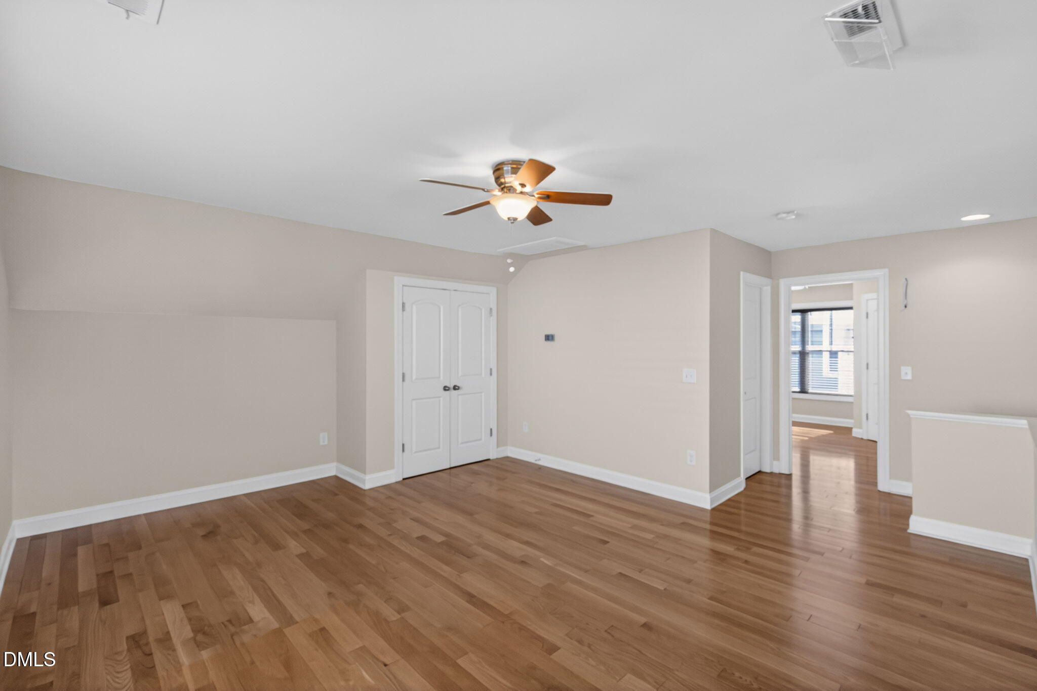 3834 Cumberland Pond Road Raleigh, NC 27606 - Photo 20 of 31 a view of an empty room with wooden floor and a ceiling fan