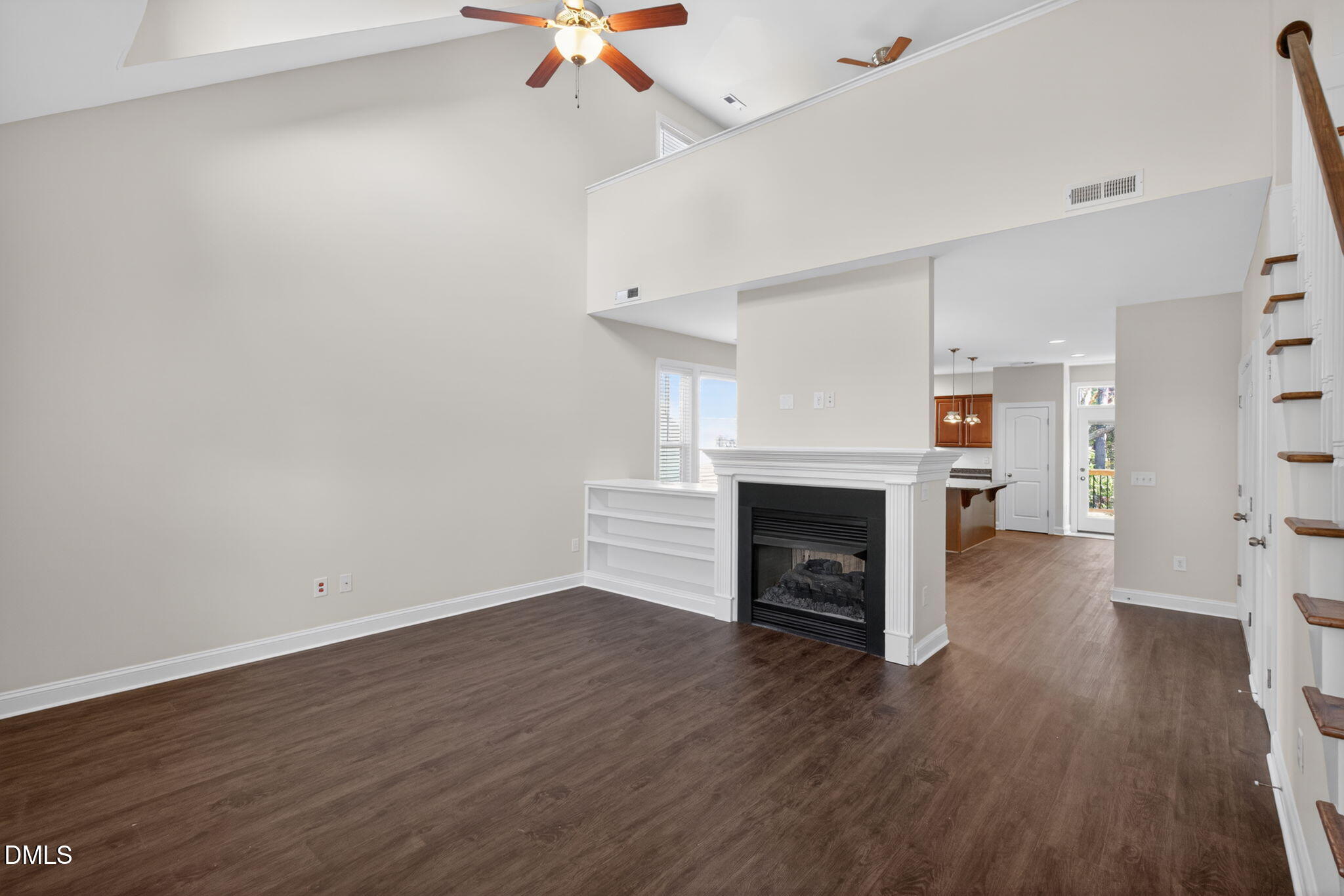 3834 Cumberland Pond Road Raleigh, NC 27606 - Photo 5 of 31 an empty room with wooden floor fireplace and windows