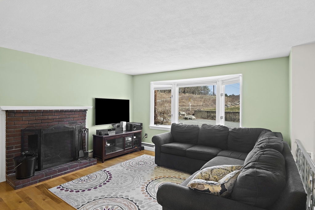 29 Dix Rd Extension Woburn, MA 01801 - Photo 12 of 40 a living room with furniture a flat screen tv and a fireplace