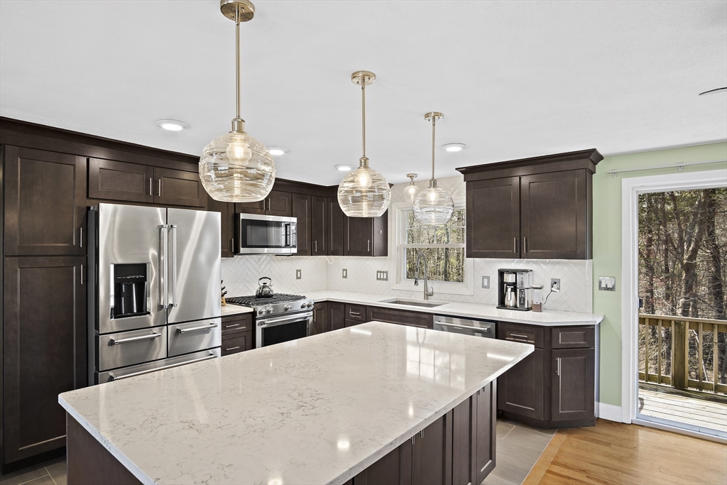 29 Dix Rd Extension Woburn, MA 01801 - Photo 6 of 40 a kitchen with stainless steel appliances kitchen island granite countertop a sink stove and refrigerator