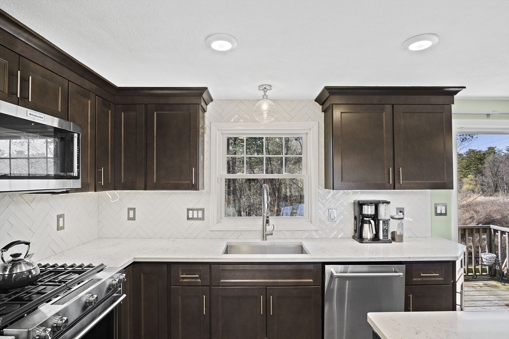 29 Dix Rd Extension Woburn, MA 01801 - Photo 7 of 40 a kitchen with stainless steel appliances a sink stove and cabinets