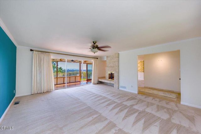 a view of an empty room with a window and fireplace