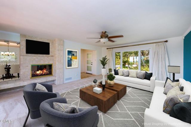 a living room with furniture a fireplace and a flat screen tv