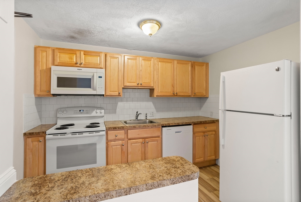 17 Davis Road, Unit C9 Acton, MA 01720 - Photo 12 of 26 a kitchen with a sink stove and refrigerator