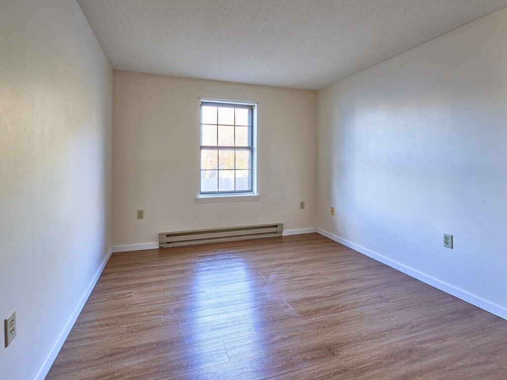 80 Stanton Street, Unit 14 Worcester, MA 01605 - Photo 18 of 26 an empty room with wooden floor and windows