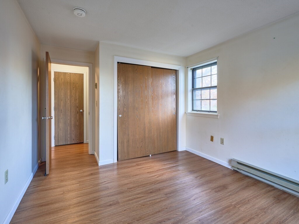 80 Stanton Street, Unit 14 Worcester, MA 01605 - Photo 19 of 26 an empty room with wooden floor and windows