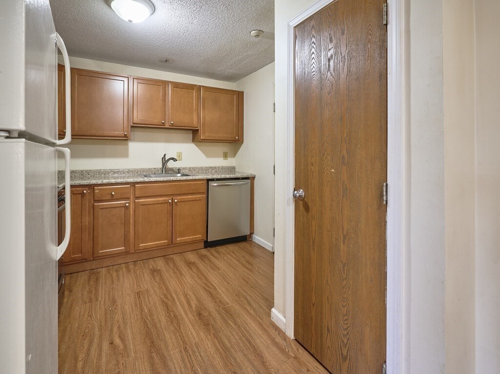 80 Stanton Street, Unit 14 Worcester, MA 01605 - Photo 7 of 26 a kitchen with stainless steel appliances granite countertop a sink and cabinets with wooden floor