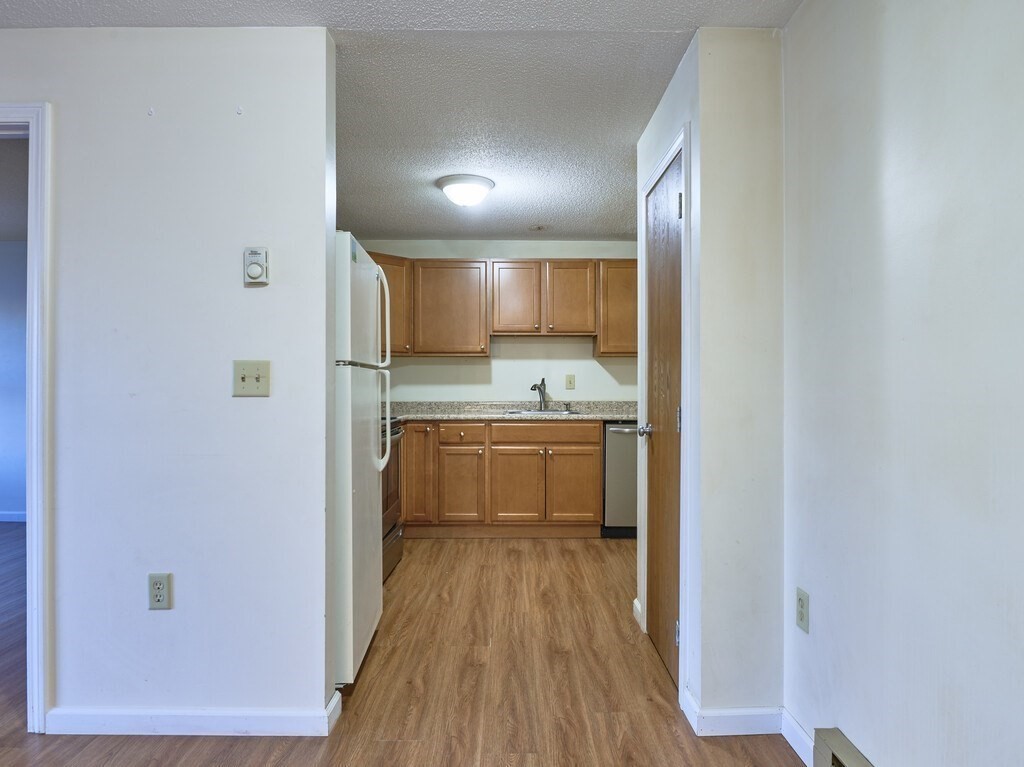 80 Stanton Street, Unit 14 Worcester, MA 01605 - Photo 9 of 26 a kitchen with a refrigerator and white cabinets