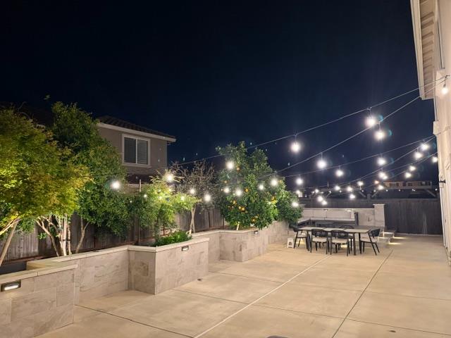 8026 Prairie Hawk Way Sacramento, CA 95829 - Photo 24 of 30 a view of a patio with dining table and chairs with plants and palm trees