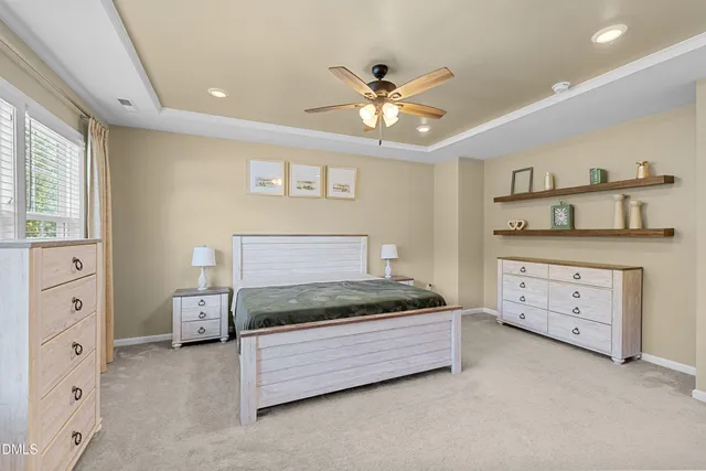 a spacious bedroom with a large bed and a chandelier