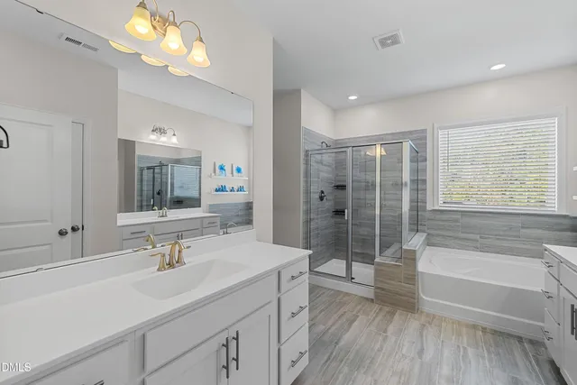 a spacious bedroom with a bed and a chandelier