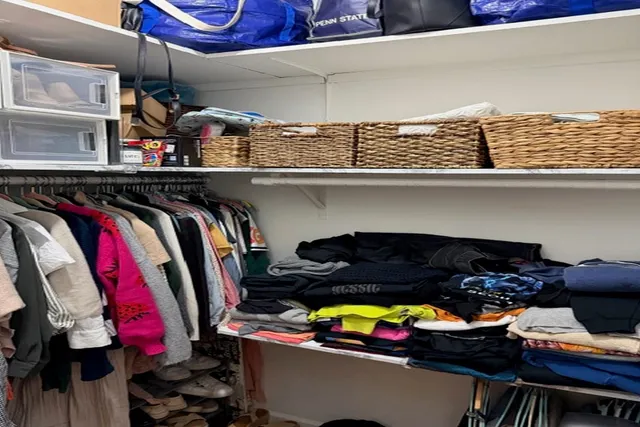 a view of walk in closet with clothes
