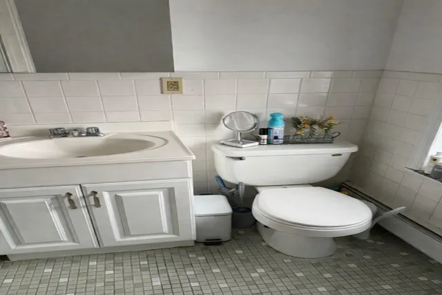 a bathroom with a toilet sink and mirror
