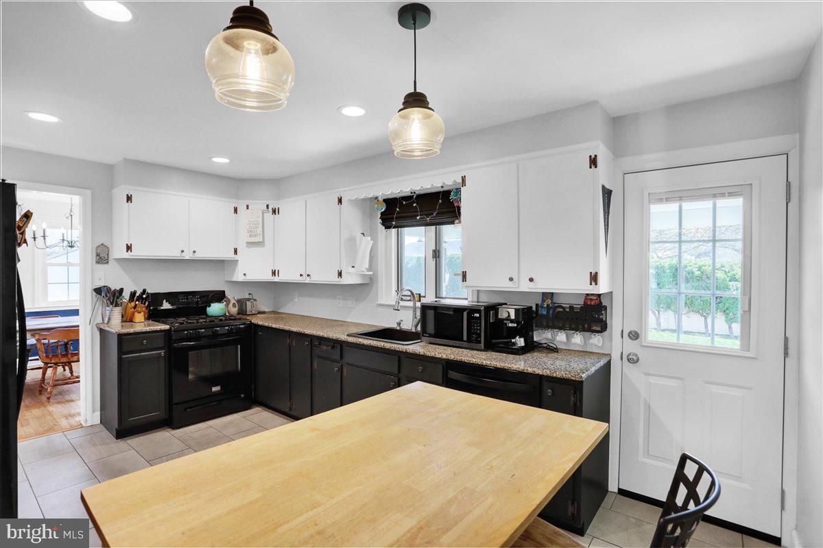 3812 Reiff Place Reading, PA 19606 - Photo 12 of 38 a kitchen with a stove a sink a kitchen island with chairs and wooden cabinets