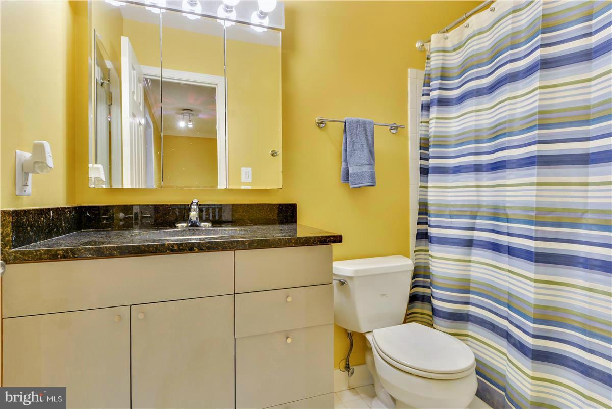 3873 Chain Bridge Road Fairfax, VA 22030 - Photo 22 of 29 a bathroom with a granite countertop toilet sink and a mirror
