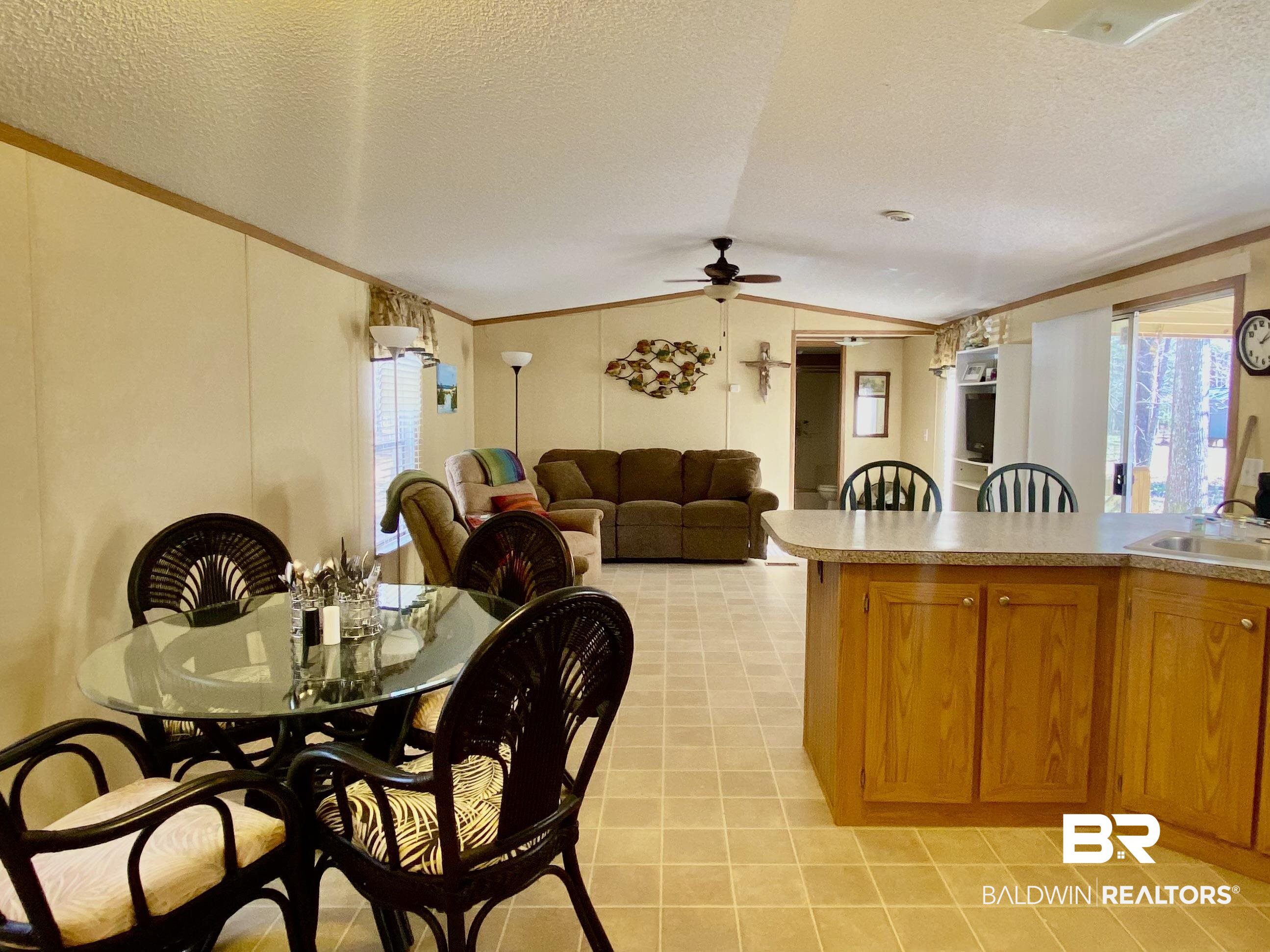 294 Eureka Way Uriah, AL 36480 - Photo 17 of 18 Kitchen with brown cabinets, lofted ceiling, light countertops, open floor plan, and a sink