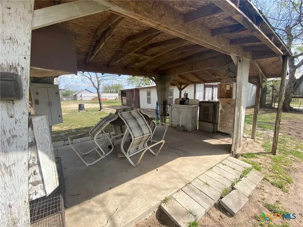 a view of a patio with table and chairs a barbeque grill with floor to ceiling window and outdoor seating