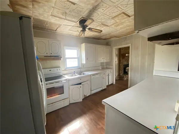 a kitchen with cabinets and wooden floor