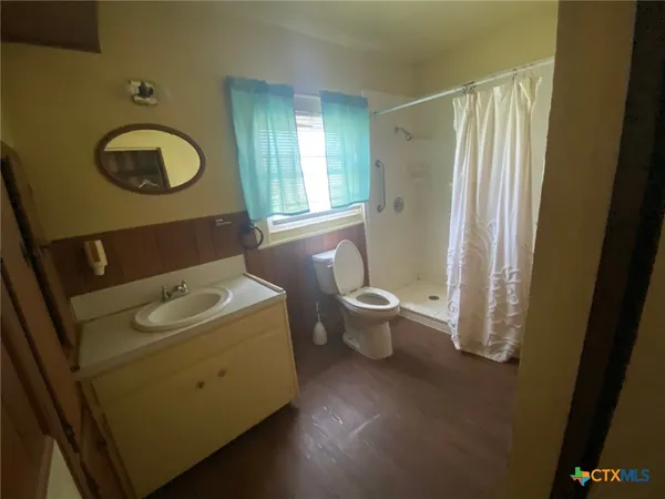 a bathroom with a toilet a sink and a mirror