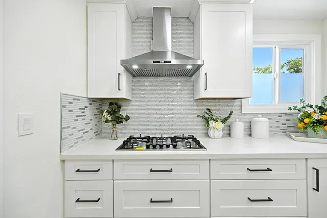 a kitchen with appliances a stove and cabinets