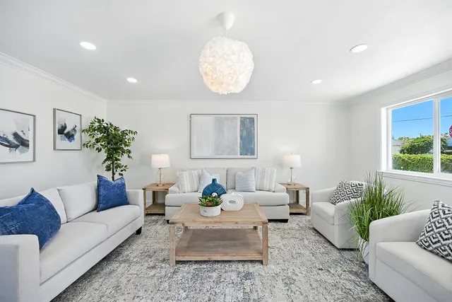 a living room with furniture potted plant and window
