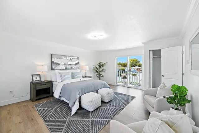 a spacious bedroom with a bed a couch and potted plant