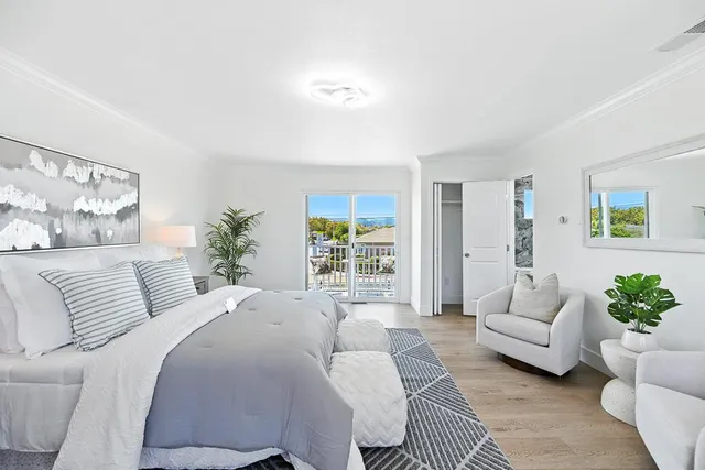 a bedroom with a large bed couch and a large window