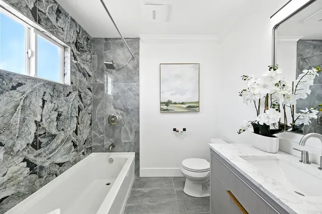 a bathroom with a granite countertop toilet a sink and a bathtub