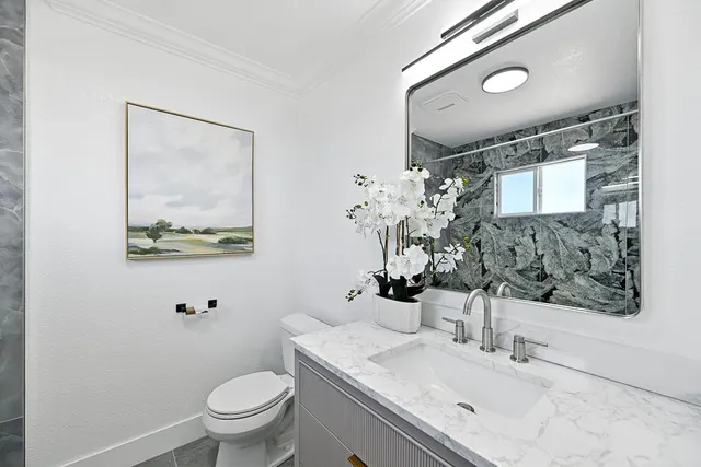 a bathroom with a toilet sink and mirror