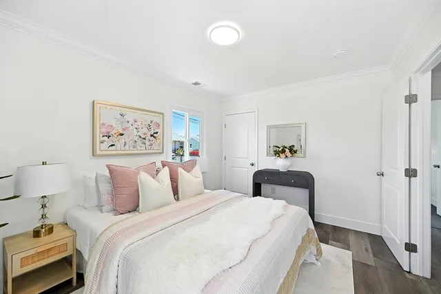 a bedroom with a bed and painting on the wall