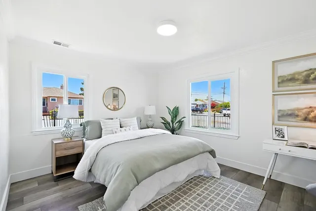 a bedroom with a bed and painting on the wall