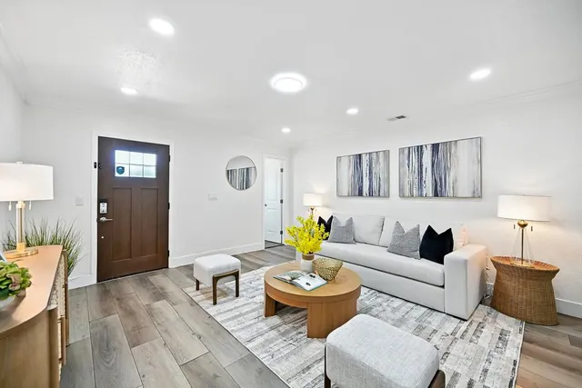 a living room with furniture and a wooden floor