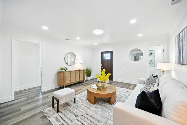 a living room with furniture and wooden floor