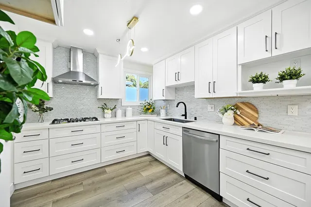 a kitchen with granite countertop white cabinets white stainless steel appliances and sink