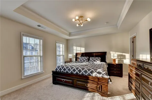 a bedroom with a bed and a chandelier