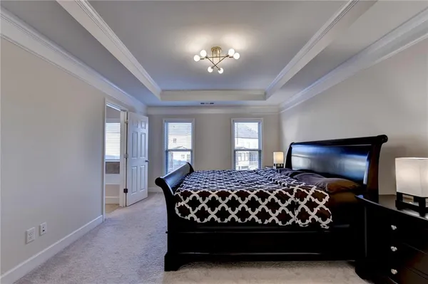 a bedroom with a large bed and a chandelier
