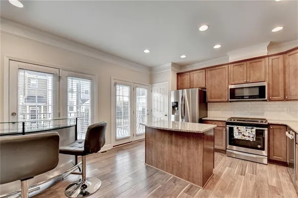 a view of kitchen with microwave a stove and wooden floors