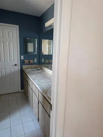 a bathroom with a granite countertop sink and washing machine
