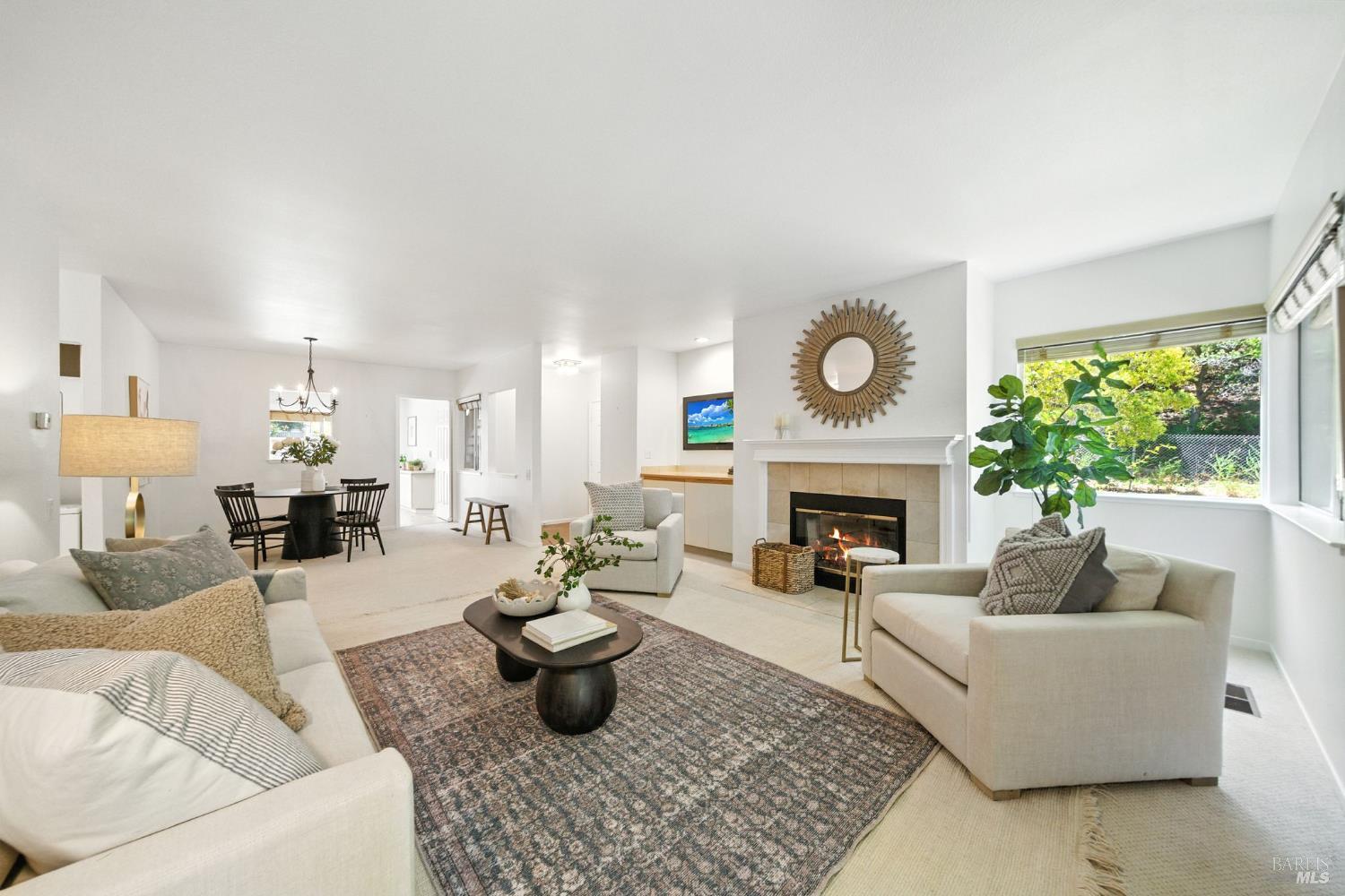 a living room with furniture a fireplace and a large window