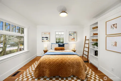a bed sitting in a bedroom next to a window