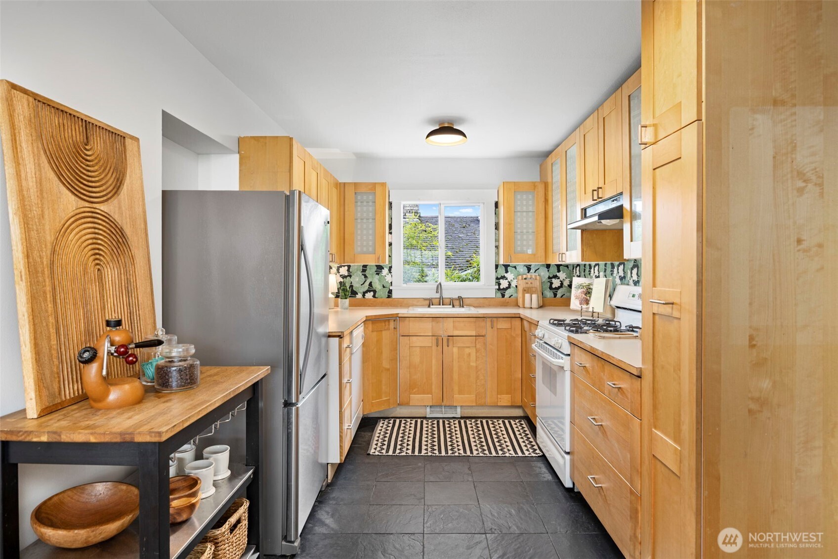7813 46th Avenue South Seattle, WA 98118 - Photo 8 of 18 a kitchen with stainless steel appliances granite countertop a refrigerator and a stove top oven
