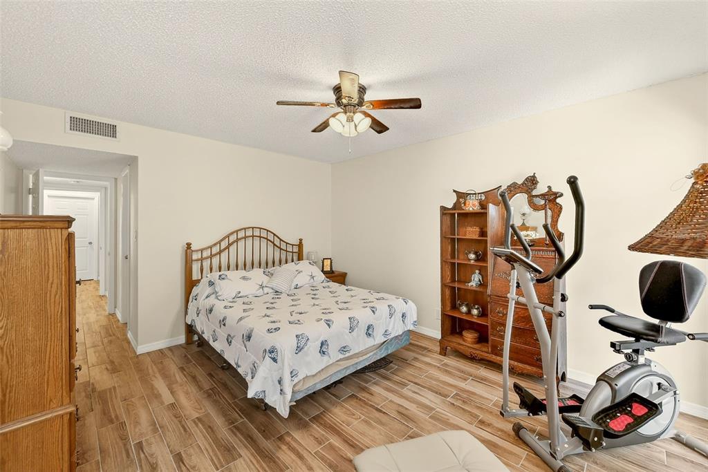 2064 Sunset Point Road, Unit 73 Clearwater, FL 33765 - Photo 24 of 58 a bedroom with a bed and wooden floor